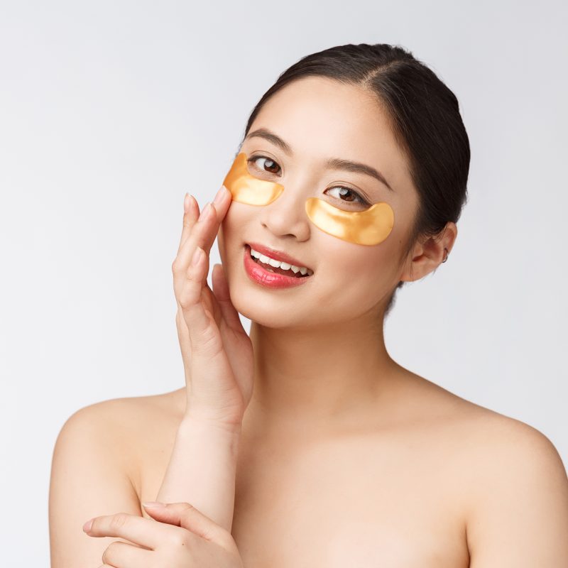 Asian beauty teenager woman care her skin with gold eye masks patches under eyes.